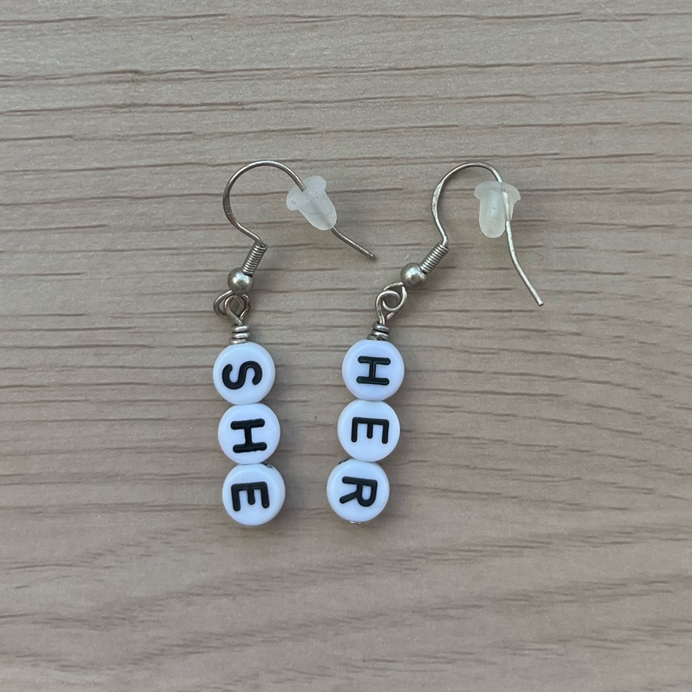 Pronoun earrings - she/her. Black and white bead earrings.